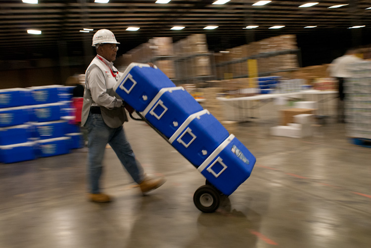 Robert Pratt of the American Red Cross moving coolers in a warehouse in Virginia.
