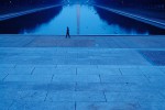 A woman walks past the reflecting pool at the Lincoln Memorial, Washington DC.