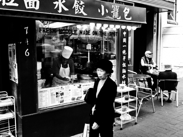 A woman walks past restaurant in Chinatown, Washington DC.