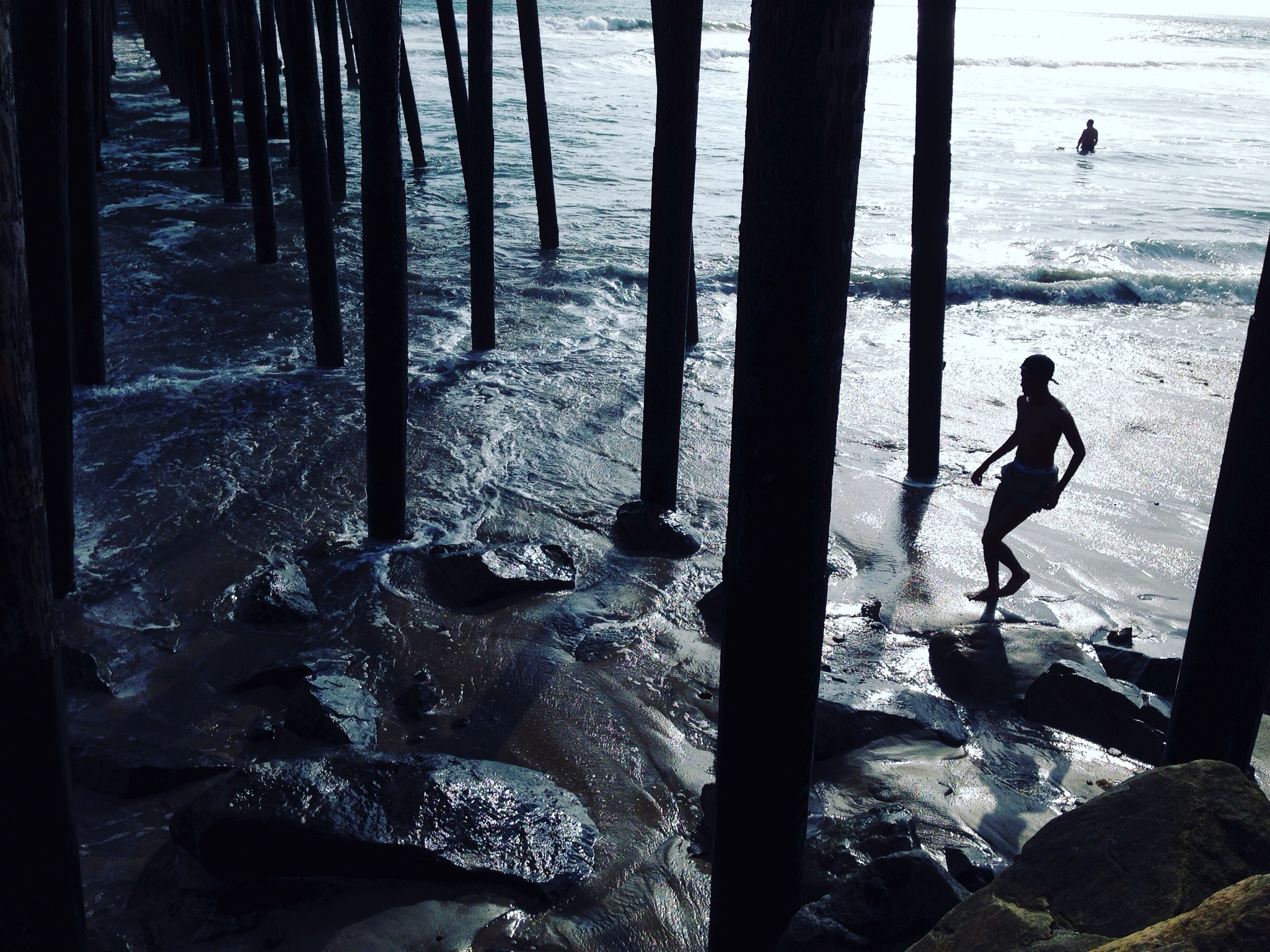 silhouette of man under oceanside pier. oceanside, california.