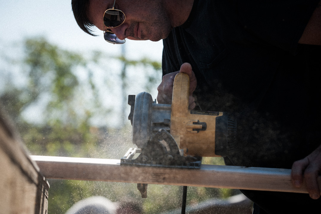 Construction worker cutting a 2x4 with circular saw.