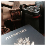 photo of passport and nikon camera, with filson bag