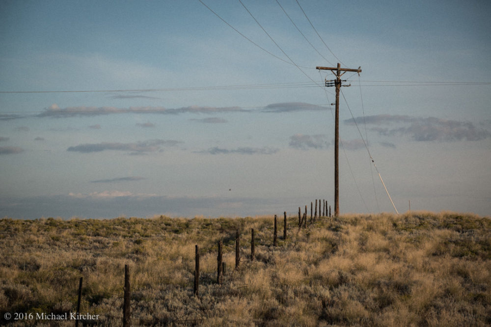 Telephone post, cable and electric wires. On the road, somewhere in Colorado.