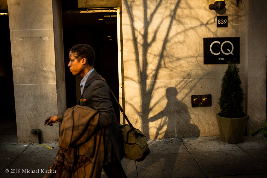 Near Farragut West metro stop a commuter passes by in the afternoon light. Washington, DC.