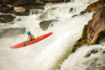 During the Great Falls Race, a Kayaker in a red kayak soars over the falls of Potomac River.